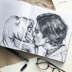 an open book with a drawing of a man kissing a woman's face on it