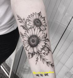 a sunflower tattoo on the left arm