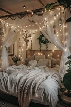 a bed with white sheets and lights on the headboard is in a room decorated with plants