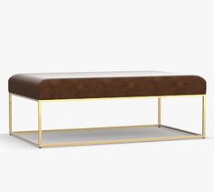 a gold and brown bench with a cushion on the bottom, in front of a white background