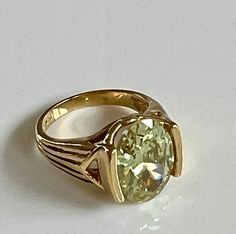 "Stunning 925 gold-plated size 7 ring with magnificent oval light green gemstone. The gold-plating is high polished and smooth. The green gemstone is catches the light and sparkles. The gemstone approximately measures 9/16\" in length and 6/16\" (1/2\")  in width.  Love the unusual setting. The ring is in excellent condition and is stamped UTC 925. Total weight 6.42 grams. Thank you for looking and shopping with Betty Jo! Questions? We are happy to help. Please look at all our other designer and Gold Oval Ring With Large Stone, Gold Oval Emerald Ring For Formal Occasions, Formal Gold Emerald Oval Ring, Gold Oval Emerald Gemstone Ring, Gold Emerald Ring With Oval Gemstone, Elegant Gold Emerald Ring With Large Stone, Gold Emerald Ring With Large Oval Stone, Green Oval High Luster Jewelry, Green Gemstones