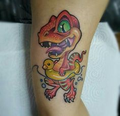 a colorful tattoo on the leg of a woman with a snake and duck in it