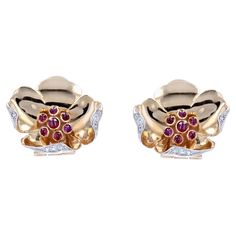 Pair of earrings in 18 karat yellow gold, eagle's head hallmark. Feminine, each ear clip represents a flower with turbulent petals edged with a pattern set with small 8/8 cut diamonds. The heart is formed by small bezel-set cabochon rubies. The attachment system is a clip for non-pierced ears. Height : 20 mm, width : approximately 20.7 mm, thickness : approximately 4.5 mm. Total weight of the jewel : approximately 9.4 g. Authentic antique jewel - French work from the 1950s. Our opinion : elegant Bezel Set Cabochon, Vintage Stud Earrings, Ruby Diamond, Flower Clip, Accessories Jewelry Earrings, Gold Flowers, Diamond Earrings Studs, Diamond Studs, Ear Piercings