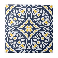 a blue and yellow patterned tile with white, yellow and black designs on the bottom