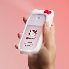 a hand holding an electronic device with a hello kitty sticker on the front cover