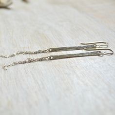 "These alluring vertical bar earrings come in either sterling silver or gold filled. They're made from 14g wire that's been hammered down and has fine cable chains dangling from them. The bars are 1 1/2\" long and longest chain is 1 1/2\". You'll definitely want to get one of each!" Minimalist Hammered Dangle Linear Earrings, Minimalist Hammered Sterling Silver Linear Earrings, Gold Bar Earrings, Glass Drop Earrings, Vertical Bar, Sea Glass Earrings, Bar Earrings, Shell Earrings, Hammered Silver