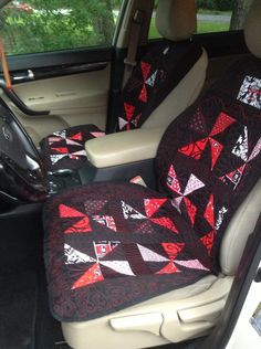 the interior of a car is decorated with red and black quilted triangles on it