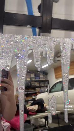 a woman taking a selfie in front of a mirror with icicles on it