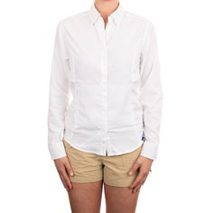 a woman in white shirt and tan shorts posing for the camera with her hands on her hips