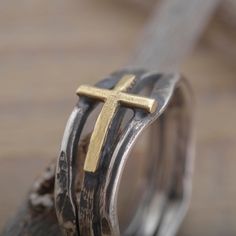 When selecting a gift of faith for a special woman in your life, you cannot go wrong with this sterling silver and gold cross ring. The surface of the ring features a rich oxidized twig texture 9mm wide with a handcrafted 14KT solid gold cross on it. You may add a more personal feeling with a short engraved by hand message on the inside. When completing checkout please write your request and your ring size in the Personalization box. You may ask for a US or non-US size (EU, UK, Swiss, etc). We o Adjustable Cross-shaped Ring For Anniversary, Spiritual Cross Shaped Rings For Gift, Gold Sterling Silver Cross Ring, Gold Cross Rings In Sterling Silver, Hand Message, Gold Cross Ring, Cross Ring, Christian Jewelry, Gold Cross