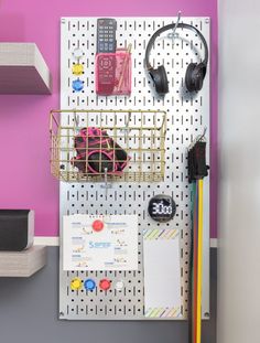 a peg board with headphones and ear phones on it next to a wall mounted bulletin board