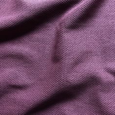 a close up view of a purple fabric with small dots on it, as well as the