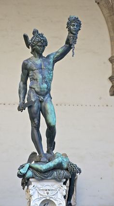 a statue of a man holding a plant in his hand