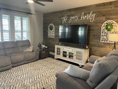 a living room with two couches and a flat screen tv mounted on the wall