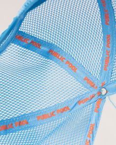 a blue mesh umbrella with orange writing on it's side and the words public pool printed on it