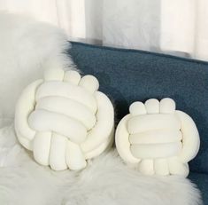 two white pillows sitting on top of a blue couch