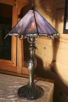 a table lamp sitting on top of a table next to a wooden paneled wall