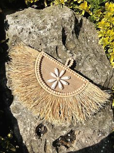 a straw purse sitting on top of a rock