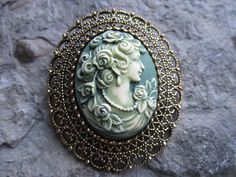 You choose silver or gold plated. Beautifully hand painted cameo pendant necklaces, individually painted and antiqued by me, so each is an original. They are offered at a reasonable price, make perfect gifts, and are wonderful quality. The cameo is set in a stunning silver or gold plated setting, please see the photos for size. I can make any of my Victorian woman cameos into this pretty piece, so please do browse and message me with your custom order. I make several varieties, colors, styles an Bronze Brooch Jewelry Gift, Antique Gold Brass Brooch For Gift, Bronze Brooch Jewelry For Gift, Victorian Handmade Pendant Brooches, Ornate Antique Gold Brooch For Gift, Vintage Brooch With Antique Finish, Antique Gold Brooch For Gift, Ornate Bronze Brooches For Gifts, Antique Bronze Brooches For Gift