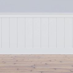 an empty room with wood flooring and white painted walls, along with a plant in the corner