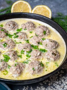 a pan filled with meatballs covered in sauce and garnished with parsley