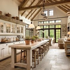 a large kitchen with lots of counter space and wooden beams on the ceiling, along with an island