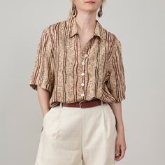 Introducing a chic vintage silk shirt for women who prefer earthy shades. This short sleeve pure silk blouse, best for women size XS to M, features a classic straight cut and relaxed fit, making it an ideal choice for breezy summer outfits in neutral tones. Its lovely beige and brown hues, accented with hints of burgundy, make it an elegant option for office wear when paired with dressy bottoms or a stylish choice for weekend ensembles with cozy shorts. This shirt is super lightweight, making it Brown Silk Tops For Spring, Summer Beige Rayon Blouse, Beige Rayon Blouse For Summer, Classic Collared Rayon Tops, Brown Silk Top For Spring, Silk Collared Summer Blouse, Collared Silk Blouse For Summer, Brown Short Sleeve Blouse For Summer, Summer Silk Blouse With Collar