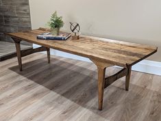 a wooden table sitting on top of a hard wood floor next to a book shelf