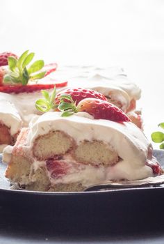 a piece of cake on a plate with strawberries