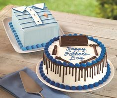 two cakes decorated with blue and white icing on top of a wooden picnic table