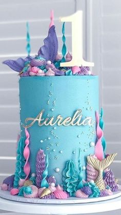 a blue cake with pink and purple under the sea decorations