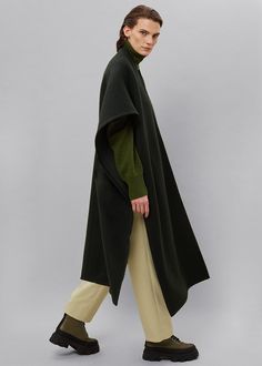 Color: Forest Green Soft woolen felt Pull-on cape Designed for a draped silhouette 90% Wool 10% Nylon Dry Clean By The Frankie Shop. Imported One Size Product Measurements: 39" Shoulder 35" Width (measured flat) 41.5" Length Model is 178cm/ 5'10" wearing size O/S Elegant Oversized Wool Poncho, Elegant Wool Poncho For Workwear, Elegant Wool Shawl Outerwear, Forest Green Coat, Alpaca Coat, Herringbone Coat, Cape Designs, Fuzzy Coat, Puffer Coats