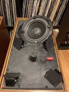 an old record player is sitting on top of a wooden table in front of records