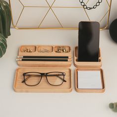 an iphone and some glasses on a table next to a mirror with a cell phone in it