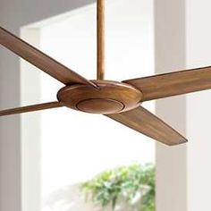 a ceiling fan with wooden blades in a room