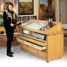 a woman standing in front of a table with drawers