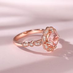 a pink diamond ring on a white surface