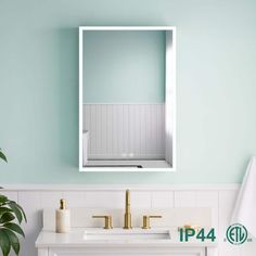 a white sink sitting under a bathroom mirror next to a green wall with a gold faucet