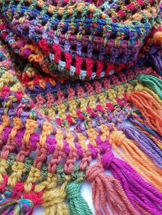 multicolored crocheted scarf laying on top of each other