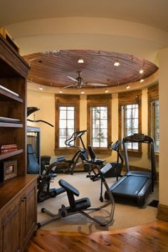 a home gym with treadmills and exercise equipment in the center, surrounded by windows