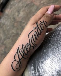 someone is holding their arm with the word november tattooed on it's left hand