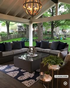 an outdoor living area with couches, tables and lamps on the outside patio covered in wicker furniture