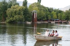 three people in a small boat on the water