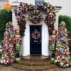 an entrance decorated with ornaments and wreaths on top of steps in front of a house