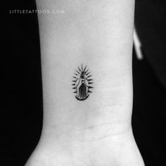 a small black and white tattoo on the wrist