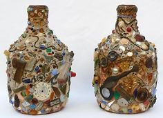 two vases made out of different types of buttons and other things on display in front of a white background