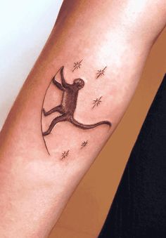 a tattoo on the arm of a person with a monkey and stars in the background