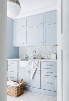 a kitchen with white cabinets and a basket on the floor