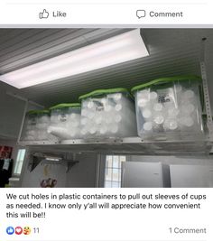 some plastic containers sitting on top of a shelf in a room with lights above them