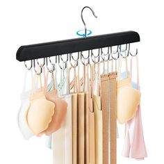 an assortment of bras hanging from hooks on a rack with clothes hangers attached to it